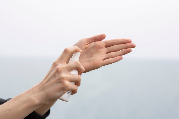 Kobieta aplikuje produkt biobójczy na dłonie
