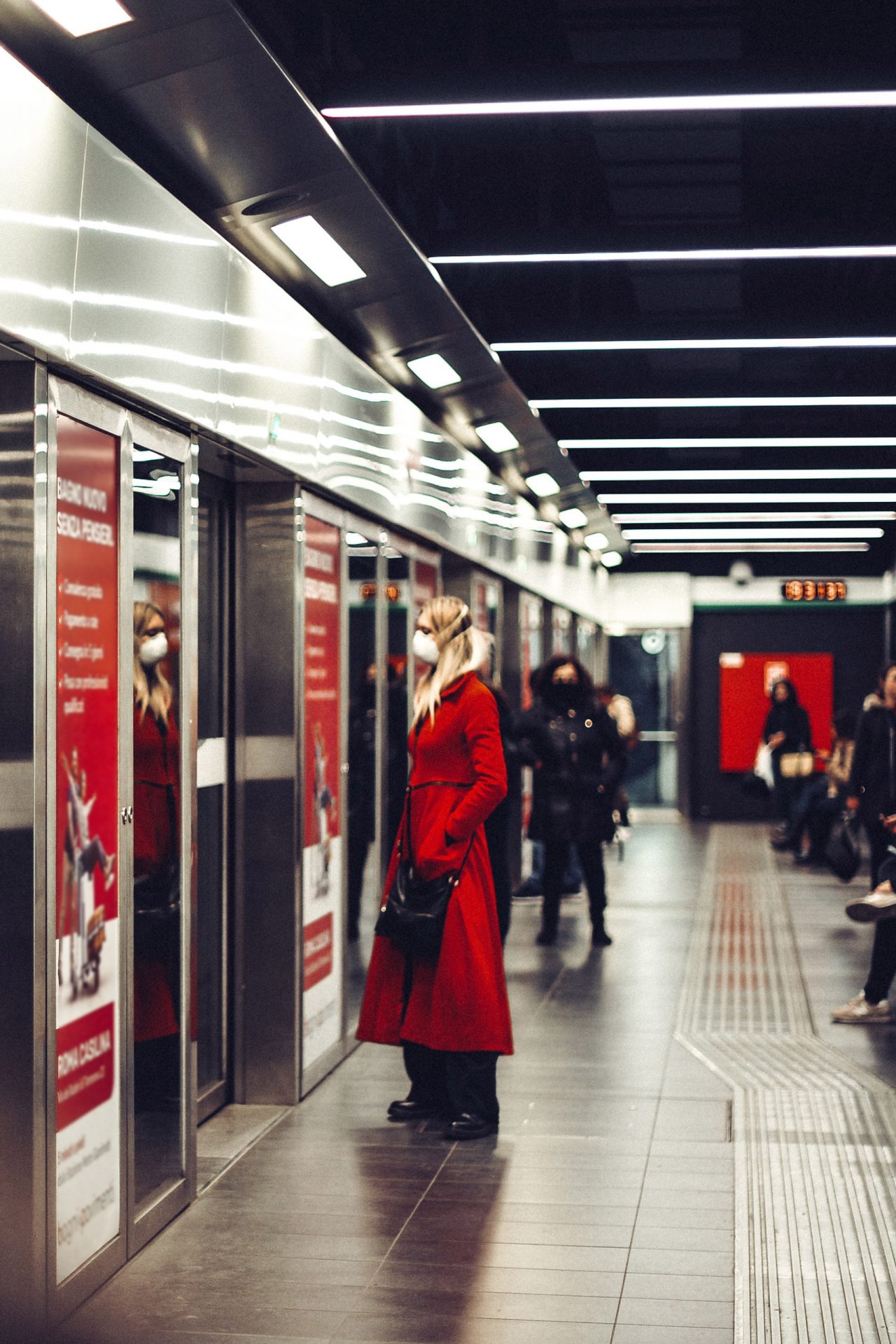Kobieta stoi przed drzwiami do wagonu metra